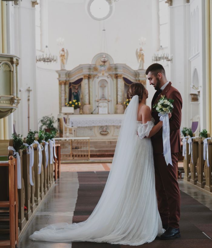 A beautiful wedding ceremony in a grand cathedral with bride and groom embracing.